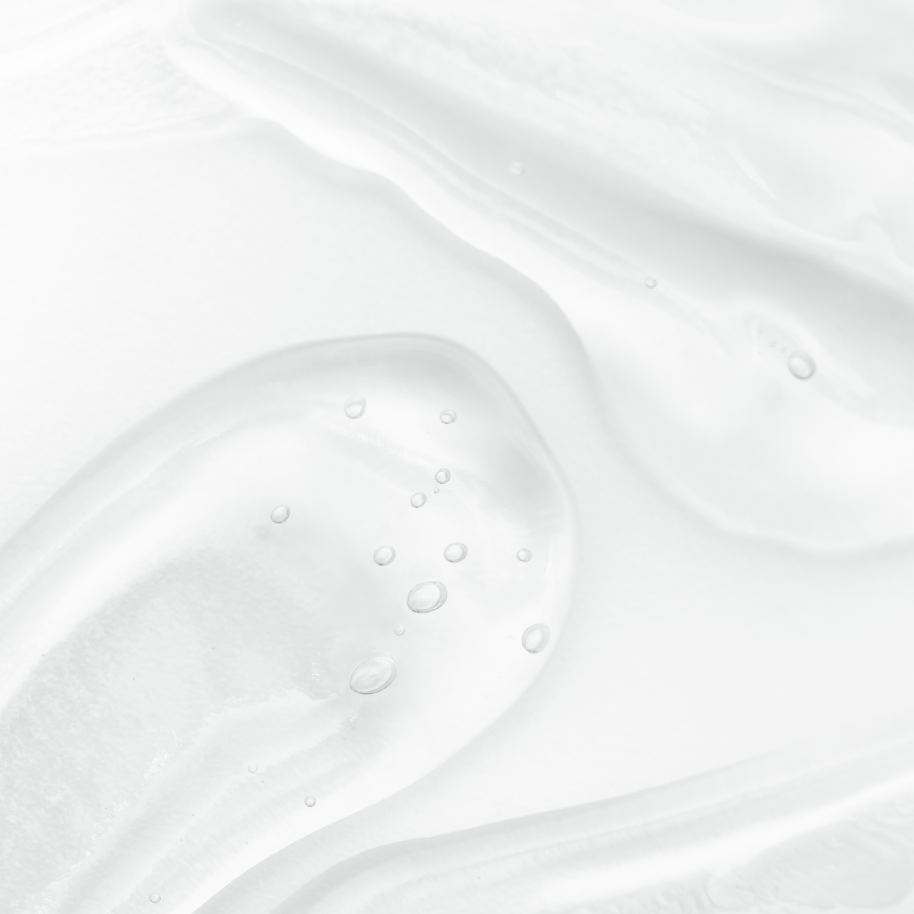 Close-up of a white liquid with bubbles on a light gray background