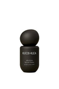 A matte black skincare bottle with a spherical cap, labeled 'KLEOS+KLEA AKATHIA Nutrient Cleanser', centered against a warm beige gradient background.